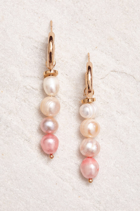 Small gold-plated hoops adorned with hand-painted freshwater pearls in shades of light pink.  